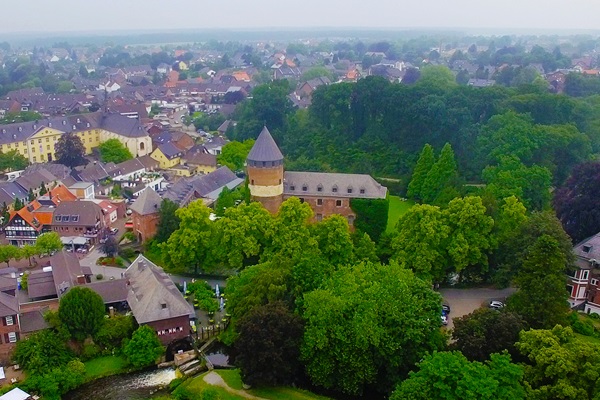 Aerial view of Brüggen Castle, surrounded by greenery and located in the town centre.
