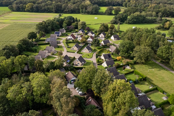 Drone shot of holiday park Posterbos with the cottages surrounded by green nature
