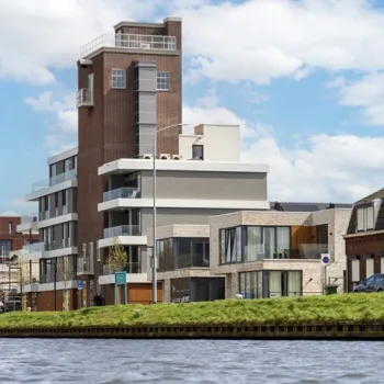 Uitzicht op de historisch gerestaureerde Mouttoren in Weert, nu een Bed & Breakfast met luxe kamers en een dakterras aan het water.